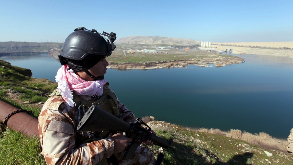 An Iraqi Kurdish Peshmerga stands guard near the Mosul Dam in northern Iraq, in February [Azad Lashkari/Reuters]