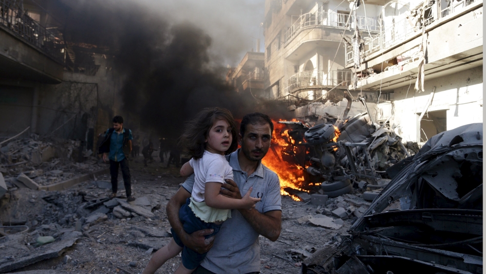 A man carries a girl reacting at a site hit by what activists said were airstrikes by forces loyal to Syria''s President Bashar al-Assad on a market place in the Douma neighborhood of Damascus, Syria