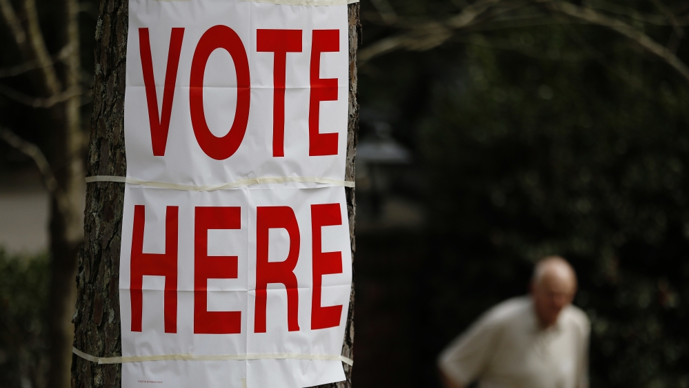A voter walks by a "vote here" sign after he cast his ballot in Alabama''s primary at a polling site, Tuesday, March 1, 2016, in Birmingham