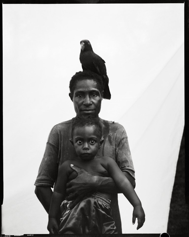 Urista Korimbun, baby Bono Korimbun and a green parrot in Govermas Village, Blackwater River, Middle Sepik. 2011 [Stephen Dupont/Al Jazeera]