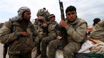 Kurdish People's Protection Units (YPG) fighters carry their weapons while riding on the back of a pick-up truck in Qamishli, Syria, March 2016. [Reuters]