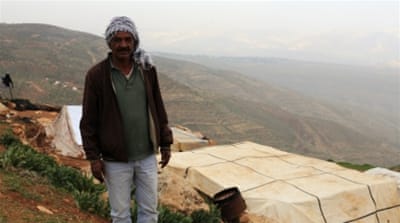 Sleiman Zawahra stands near tents donated by the Palestinian Authority after Israeli forces demolished his Bedouin community [Abed al-Qaisi/Al Jazeera]