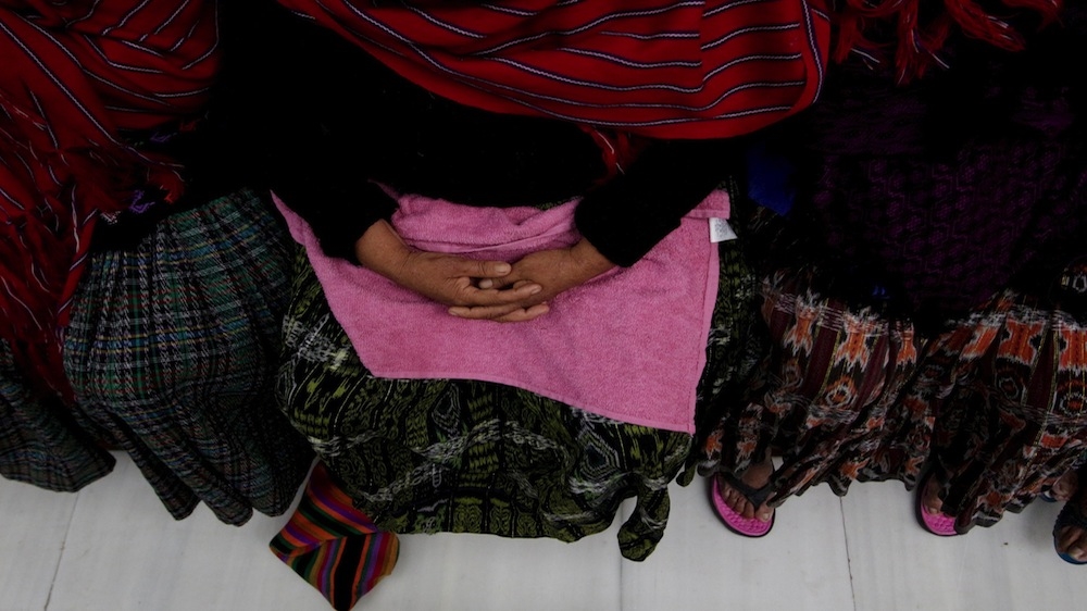 Ethnic Q'eqchi women sit with their faces covered during the final hearing in the Sepur Zarco case [REUTERS/Josue Decavele]