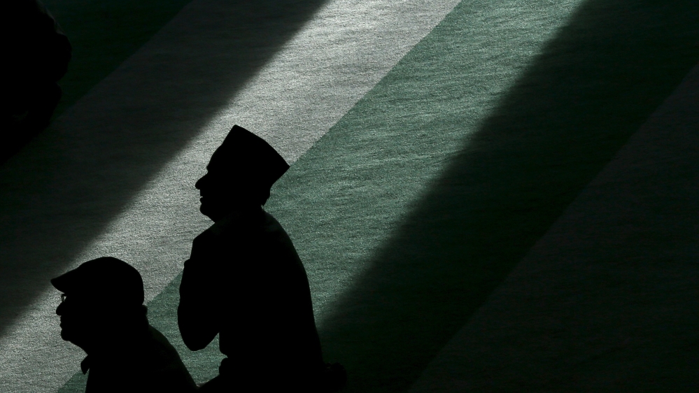 Muslim men listen during the Friday prayer at the Baitul Futuh Mosque in Morden