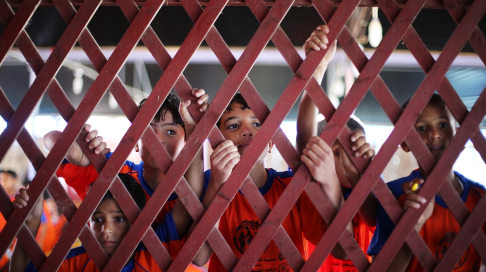 Palestinian boys look at participants during a local marathon organized by Culture and Free Thought association, in Khan Younis in the southern Gaza Strip