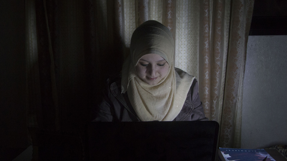 Student Aya Nashwan says that studying by flashlight or low-intensity LED lights has caused her painful headaches [Ylenia Gostoli/Al Jazeera]