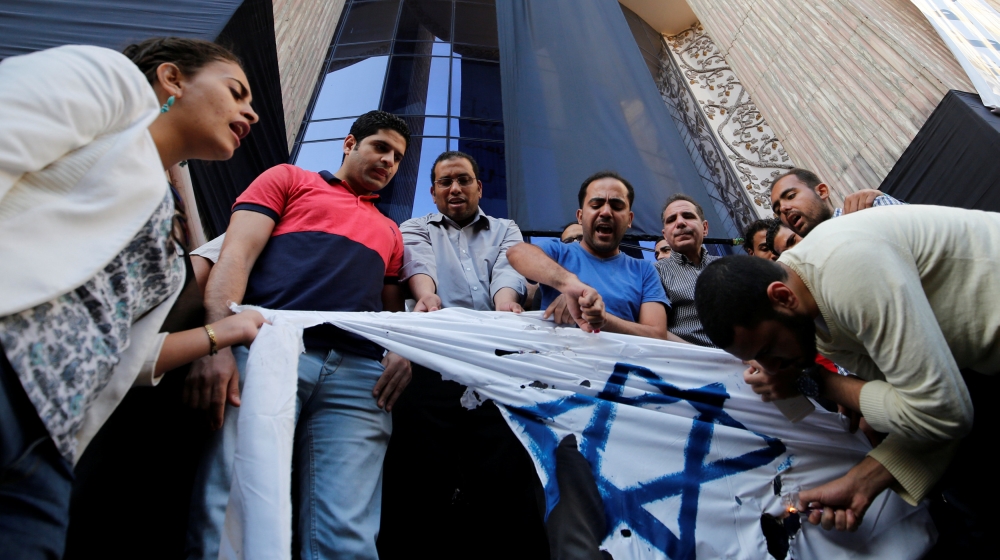 Activists burn a makeshift Israeli flag in protest against a possible visit by Israeli Prime Minister Benjamin Netanyahu to Egypt, in front of the Syndicate of Journalists in Cairo, Egypt [REUTERS]