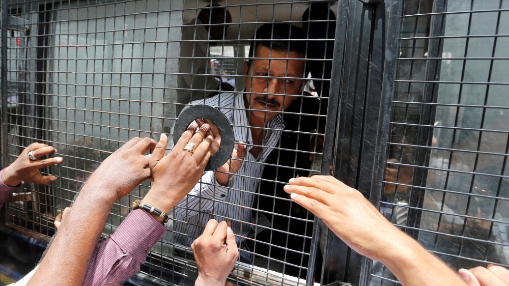 A convict in connection with a riot in Gujarat in 2002 is seen inside a police vehicle at a court after the sentencing in Ahmedabad