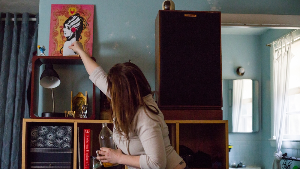  Becca puts out some incense she has been burning  [Carolyn Bick/Al Jazeera] 