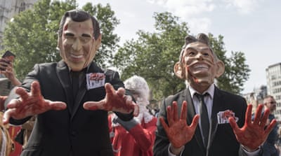 Protesters dressed as Tony Blair and former George W Bush demonstrate as they wait for the release of the Chilcot Inquiry in London [EPA]
