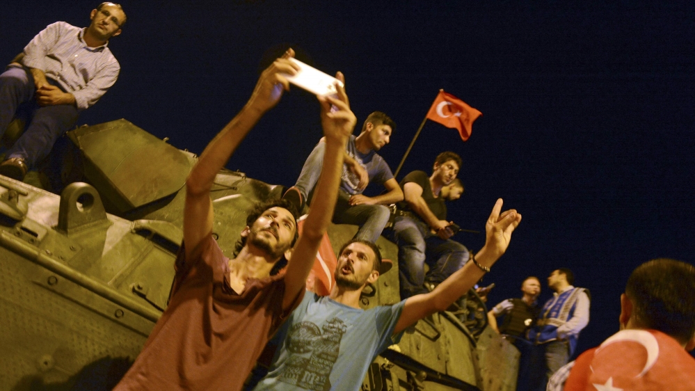 Supporters of Tukish President Erdogan take a sefie with an armored vehicle in front of Ataturk Airport in Istanbul
