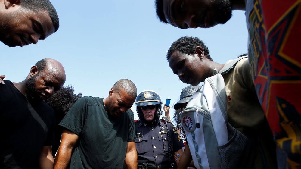 Dallas police takes part in a prayer circle after a Black Lives Matter protest following the multiple police shootings in Dallas [Carlo Allegri/Reuters]