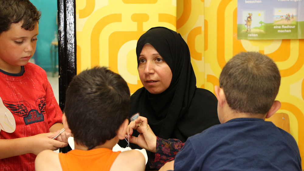 Abeer Mawad began teaching English to women and children in the playground armed only with a chair and an Ikea blackboard  [John Psaropoulos/Al Jazeera]