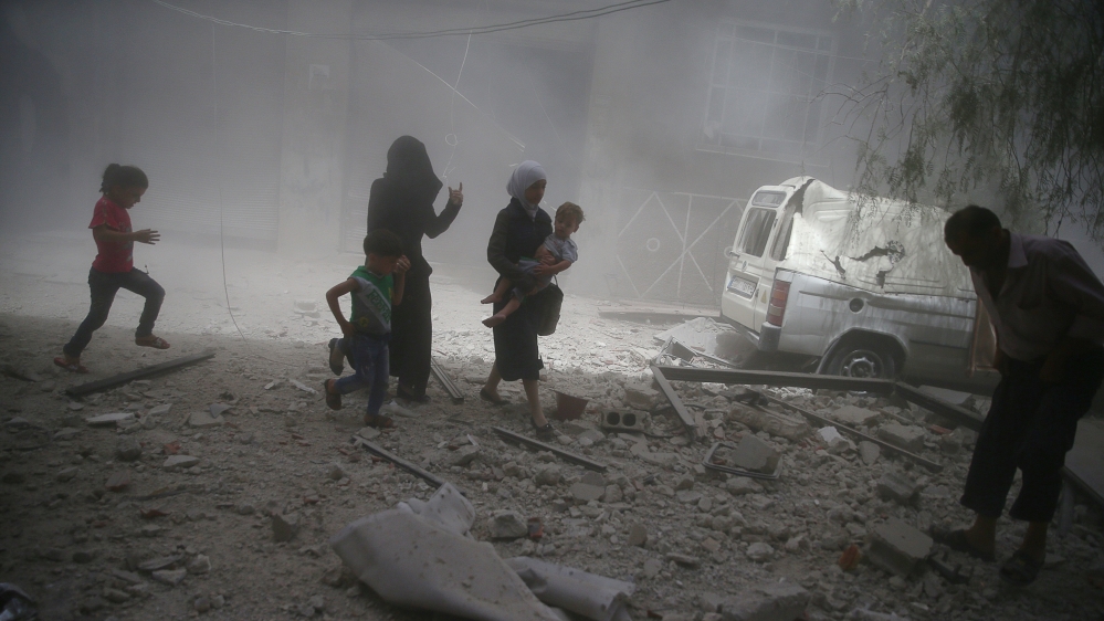 Residents flee a site after an air strike on the rebel-held besieged town of Douma, eastern Damascus suburb of Ghouta