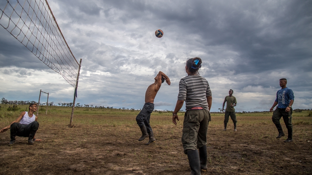Fighters and civilians play volleyball together [Tomas Ayuso/Al Jazeera] 