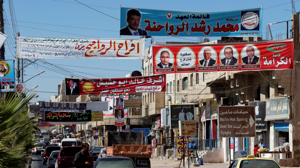 Electoral posters for parliamentary candidates are seen ahead of the general elections on Tuesday, in Madaba city, near Amman