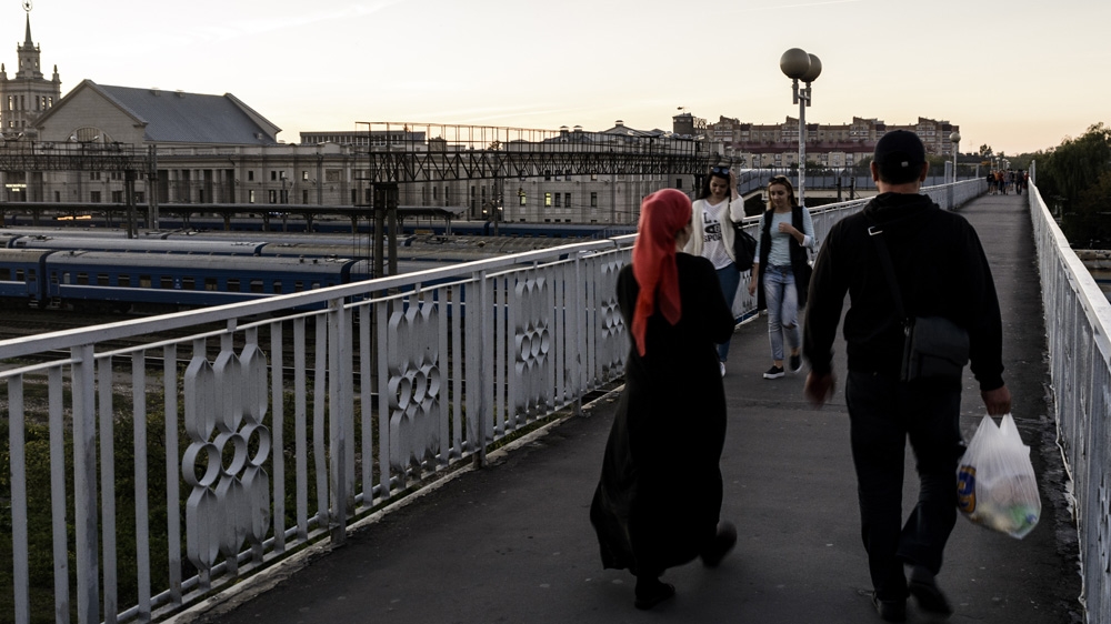 A couple having bought groceries for themselves and their children return to the train station where they spend their nights [Ben Gerdziunas/Al Jazeera] 