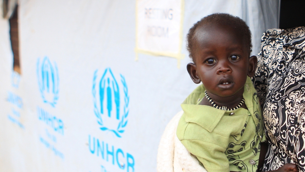 A South Sudanese refugee woman carries her child at the UNHCR managed refugees reception point at Elegu, within Amuru district of the northern region near the South Sudan-Uganda border