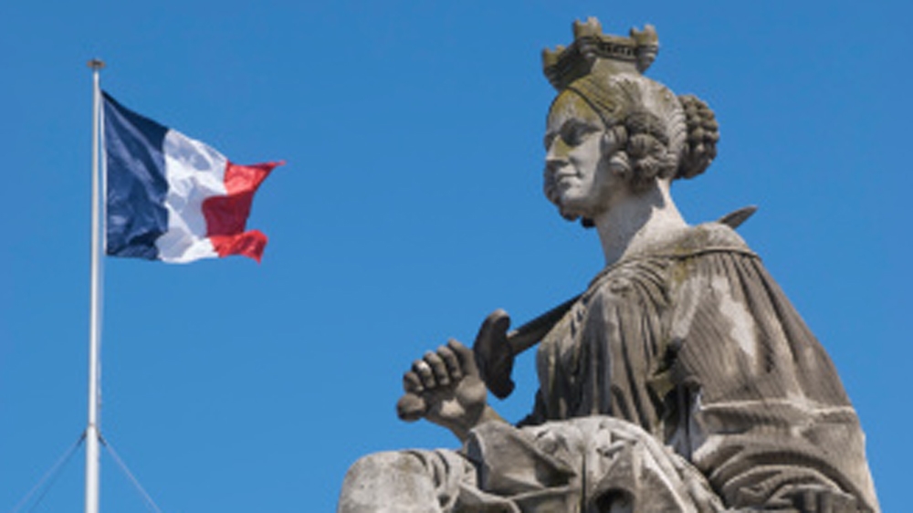 Statue of Marianne, the "Lady of Liberty", with French flag in background [Getty]