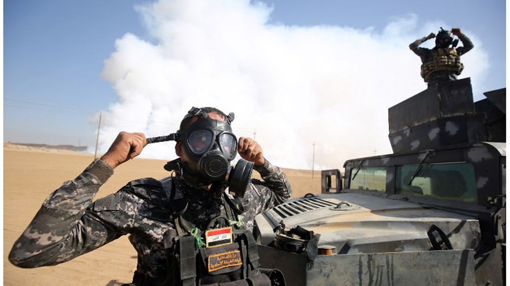 Iraqi forces wear gas masks for protection