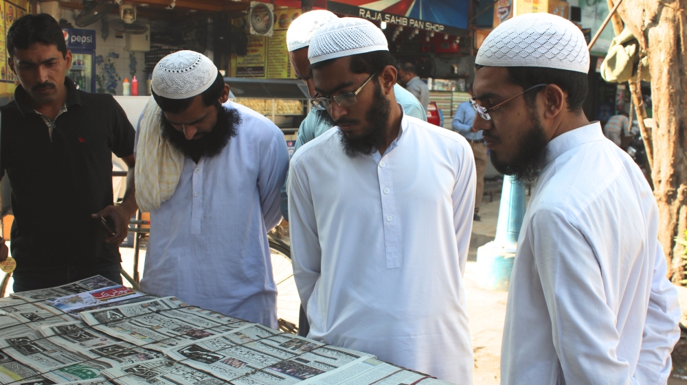 Pakistanis take in news headlines the day after the election [Sanam Maher/Al Jazeera]