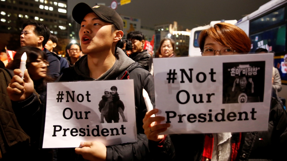Protesters shout slogans after they are blocked by riot policemen in a road nearby the presidential Blue House during their march calling South Korean President Park Geun-hye to step down in Seoul