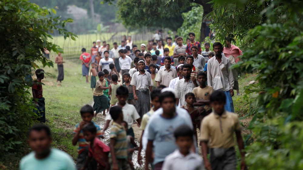 Men walk at a Rohingya village outside Maugndaw in Rakhine state