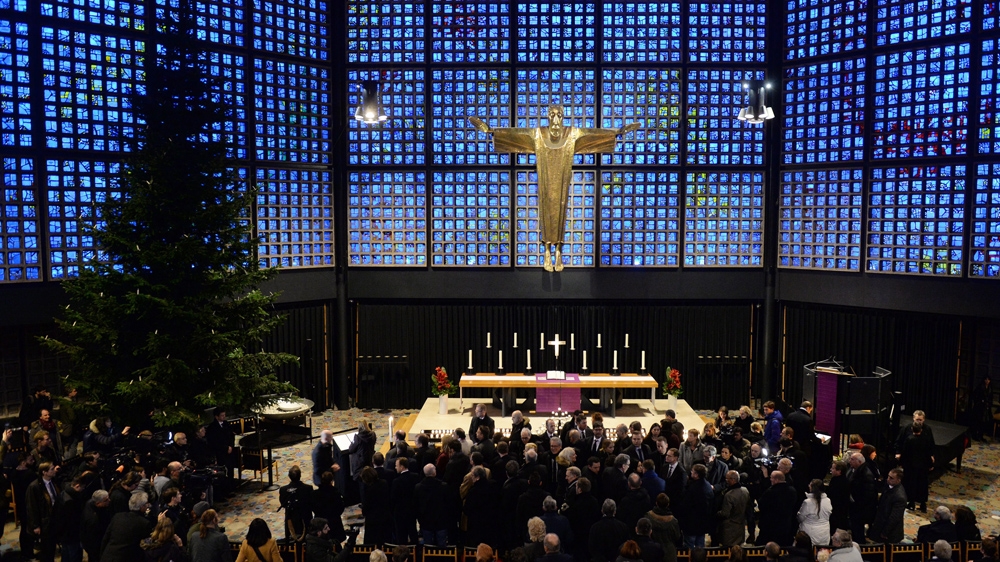  Mourners pray for victims of the Berlin Christmas market attack, at the Kaiser Wilhelm Memorial Church in Berlin [Maurizio Gambarini/EPA] 