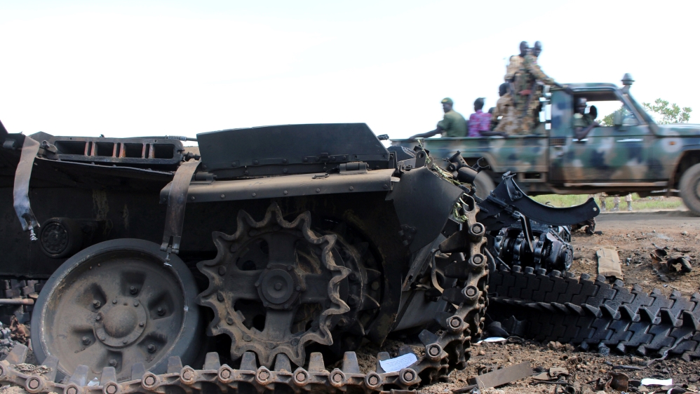 Sudan People’s Liberation Movement (SPLM) soldiers drive past military tanks that were destroyed and abandoned in the recent fighting in the Jabel area of Juba
