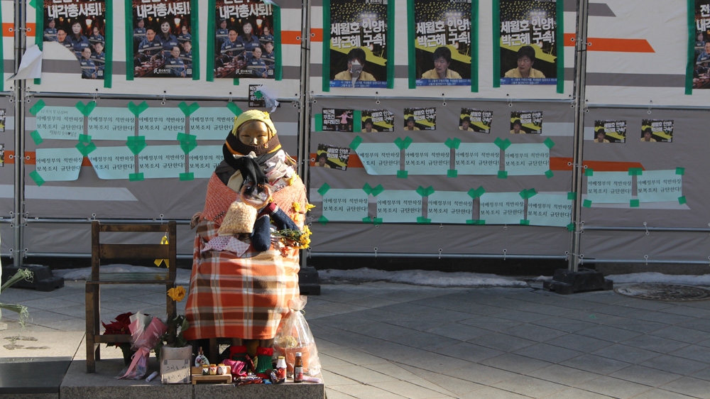 The statue of a Korean comfort woman faces the Japanese embassy in Seoul [Steven Borowiec/Al Jazeera]