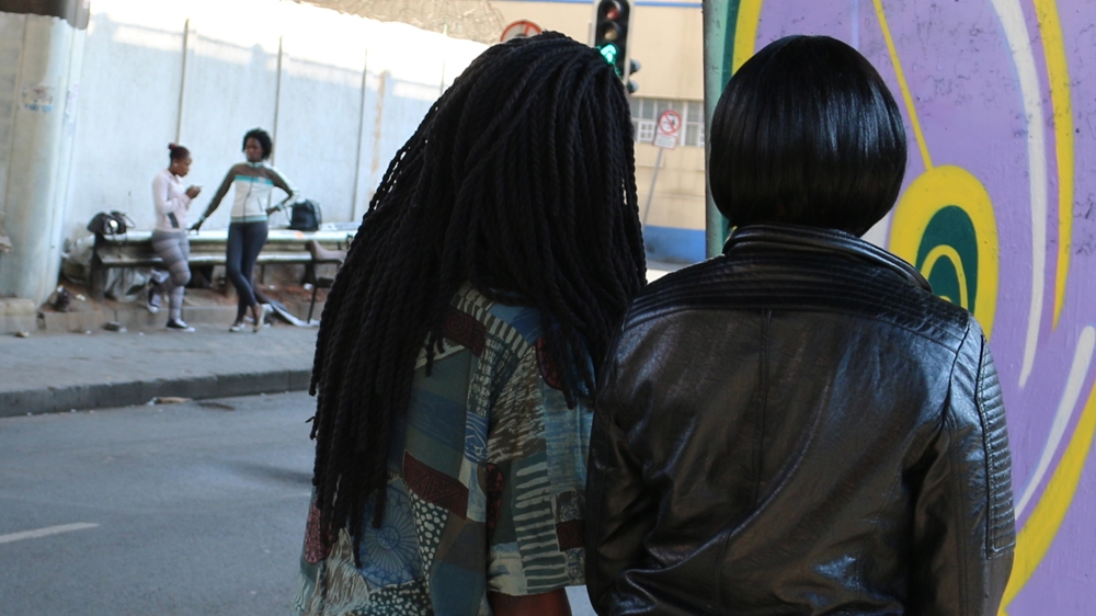 
Shaun Bibi, a paralegal and former sex worker with the Women's Legal Centre in Johannesburg, talks to Tlaleng on the stroll about her constitutional rights [Caelainn Hogan/Al Jazeera]
