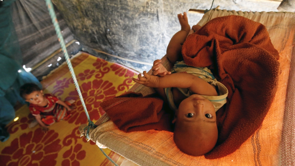 A Rohingya refugee child reacts to the camera as lies on a cradle at Kutupalang Unregistered Refugee Camp