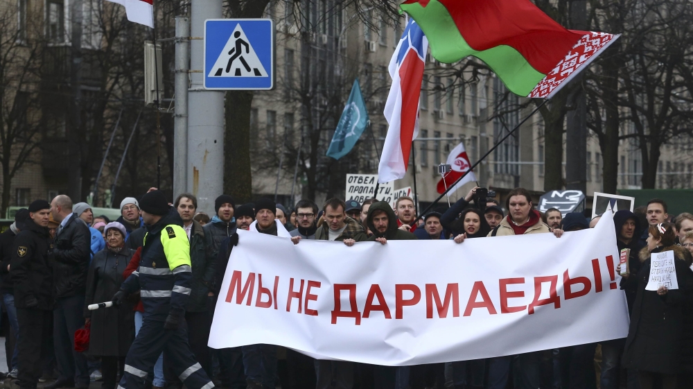 People hold banner at protest against increased tariffs for communal services and new taxes, including tax for those who are not in full-time employment, in Minsk