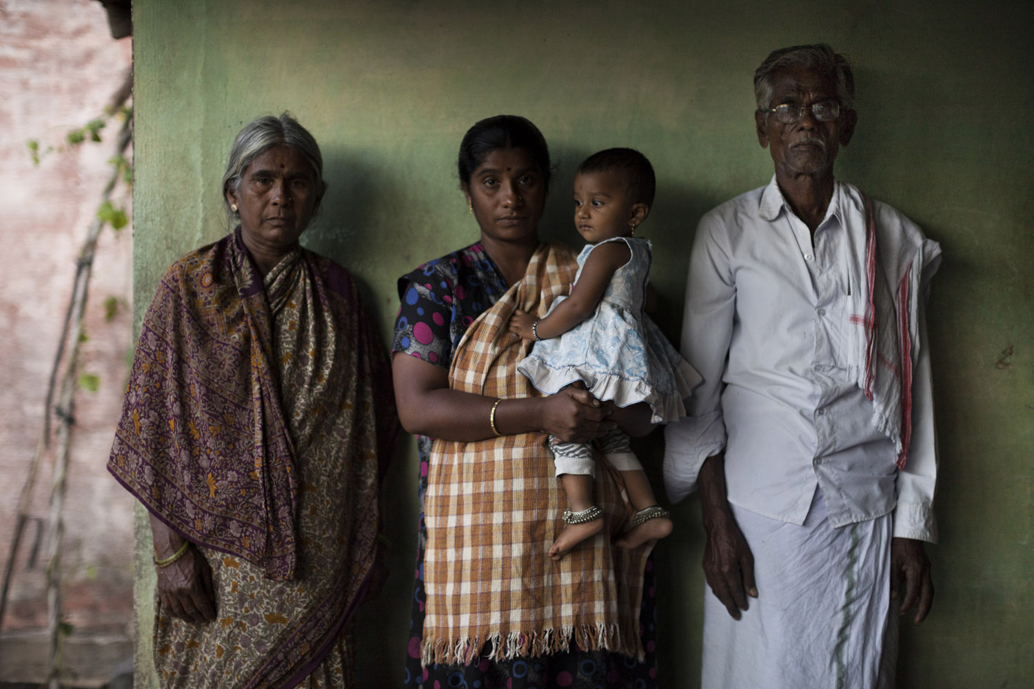 Shivanna's wife, Sushma, 32, holds their one-year-old daughter. Next to her are Shivanna's mother, Savithriamma, 65, and his father Kempegowda, 72 [Janos Chiala/Al Jazeera]