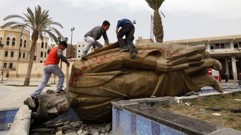 Children play on the statue of President Bashar Al-Assad's father, Hafez Al-Assad, in Raqqa province, eastern Syria on March 13, 2013 [Reuters/Hamid Khatib]