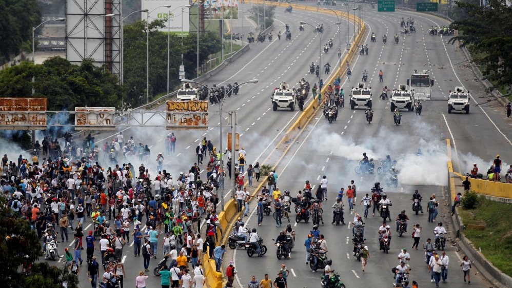 Demonstrators run away from tear gas during clashes with police while rallying against Venezuela''s President Nicolas Maduro in Caracas