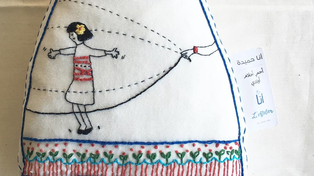 This doll's name is Hamida. The tag reads: 'I am Hamida ... I protect the dreams of my children' [Courtesy of the Ana Collection/Al Jazeera]