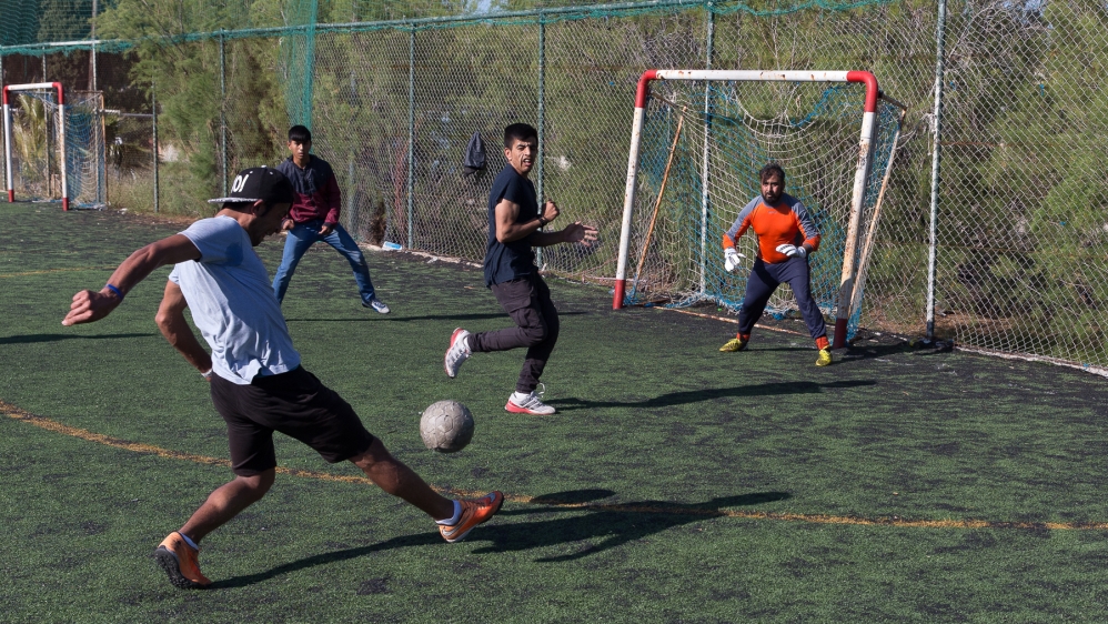 Masoud Qahar passes time by playing football and helping with repairs around the Elliniko camp [Kelly Lynn Lunde/Al Jazeera]