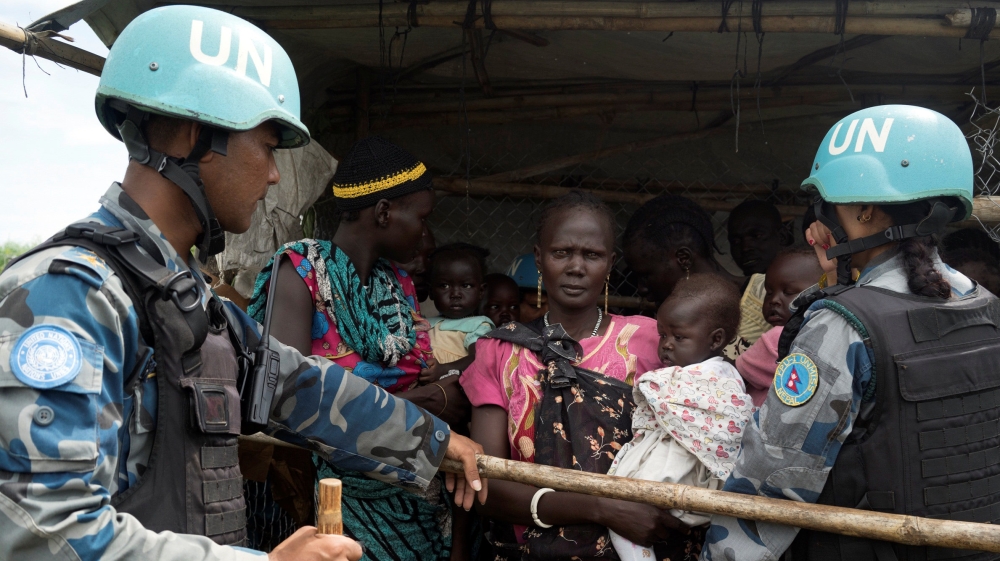 UN peacekeepers control South Sudanese women and children before the distribution of emergency food supplies at the United Nations protection of civilians site 3 hosting about 30,000 people displaced