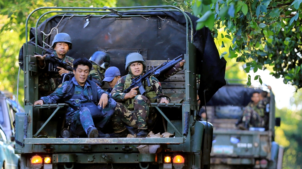 Government soldiers on military vehicles patrol after a continued assault on fighters from the Maute group who have taken over large parts of Marawi City [Romeo Ranoco/Reuters]