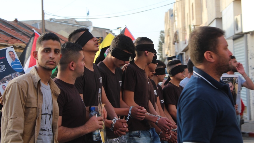 Young Palestinian men march through central Ramallah in solidarity with the Palestinian prisoners on hunger strike [Nigel Wilson/Al Jazeera]