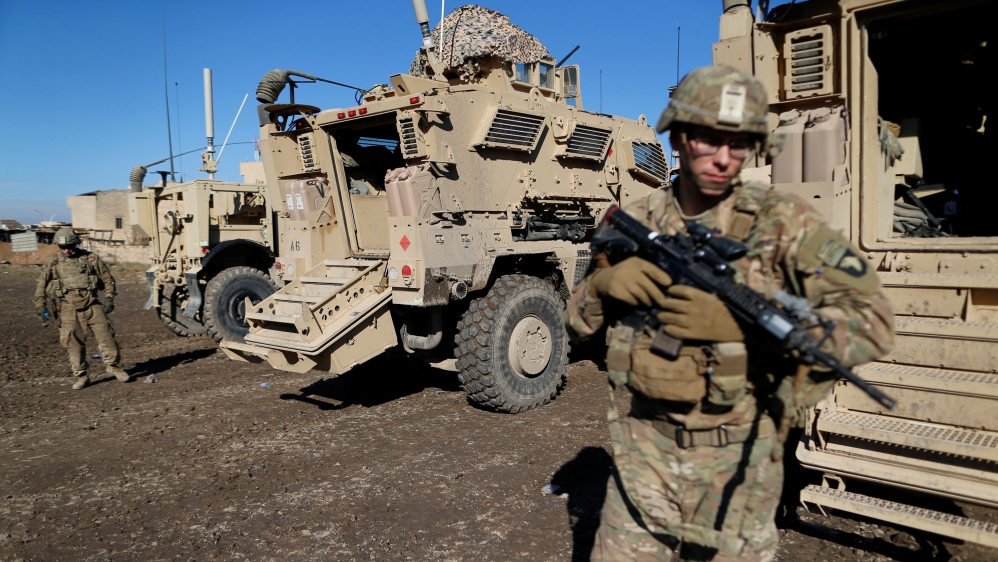 US. army soldiers stand next a military vehicle in the town of Bartella