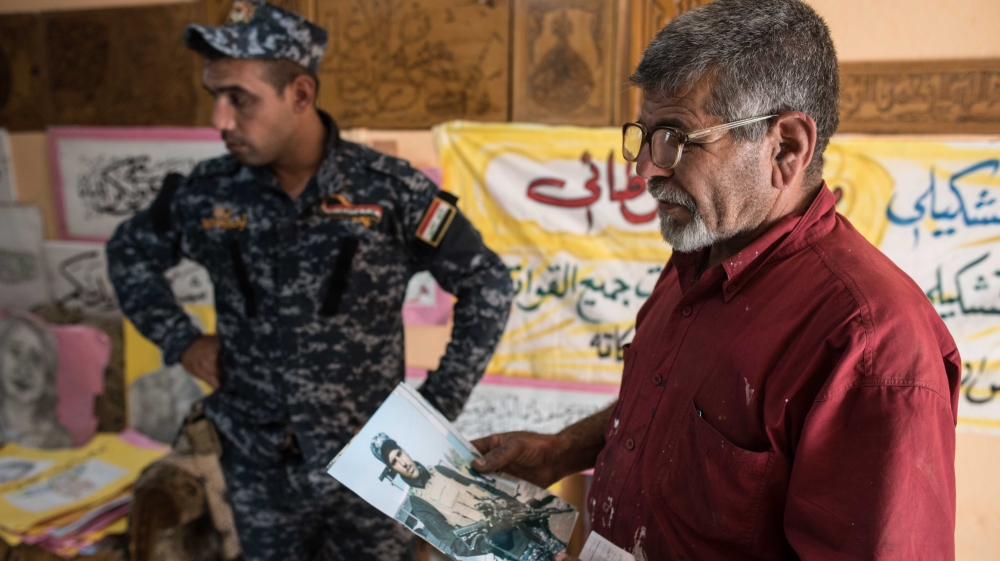 Taei says he's painted over 100 memorial posters of fallen Iraqi soldiers [Campbell MacDiarmid/Al Jazeera]