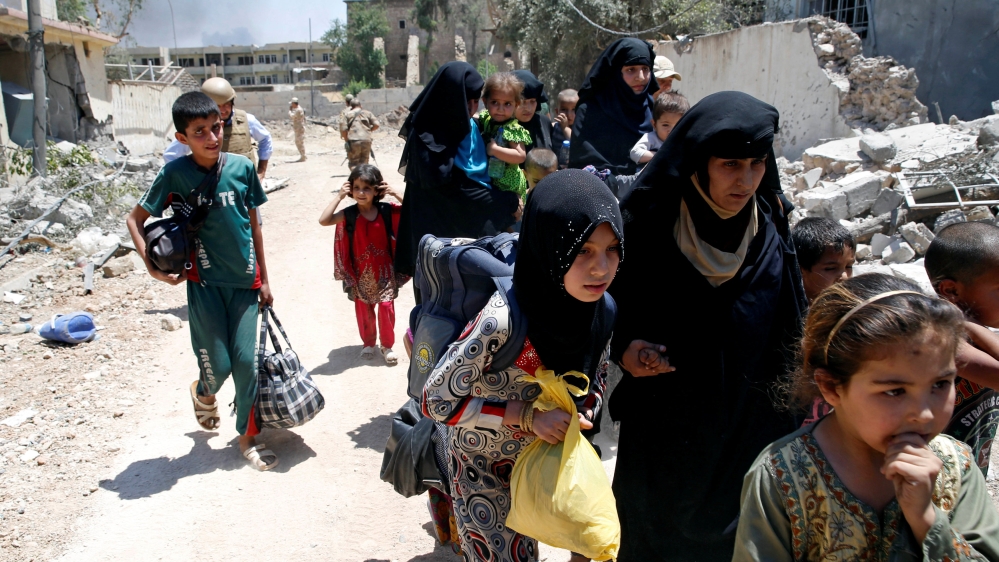 Civilians walk towards the Iraqi army positions after fleeing their homes due to clashes in the Shifa neighbourhood of west Mosul [Erik De Castro/Reuters]