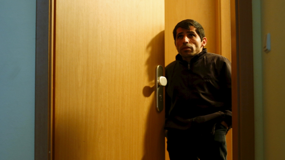 Majdi Khatun, a Lebanese father of four, stands by the door of an asylum shelter in Clausnitz [Hannibal Hanschke/Reuters]