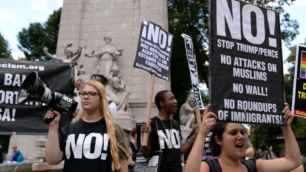 Activists hold placards as they protest against the U.S. Supreme Court decision to revive parts of a travel ban on people from six Muslim-majority countries in Columbus Circle, Manhattan
