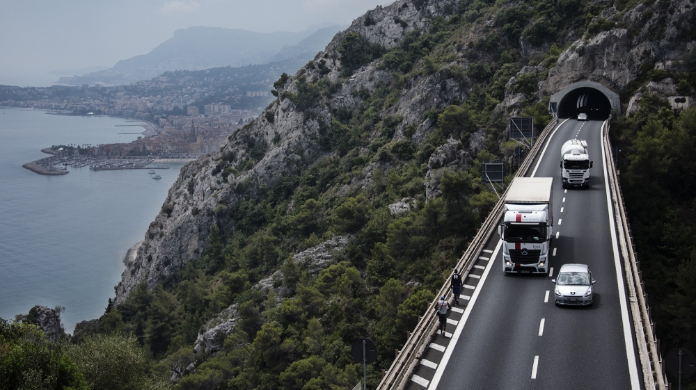 Two Sudanese men walk along the motorway on the way back down from the Pass of Death [Maurizio Martorana/Al Jazeera]