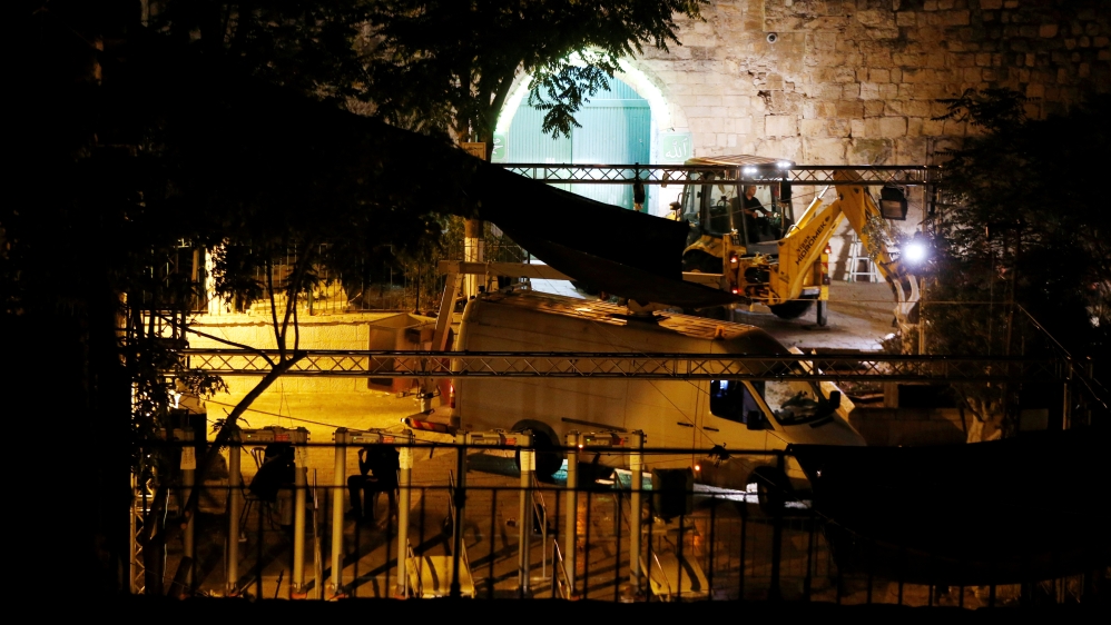 Israeli security forces stand next to heavy machinery as metal detectors