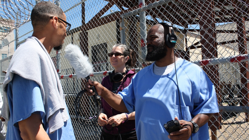 Earlonne and Nigel interview an inmate in the prison yard [Eddie Herena/Courtesy of Ear Hustle]