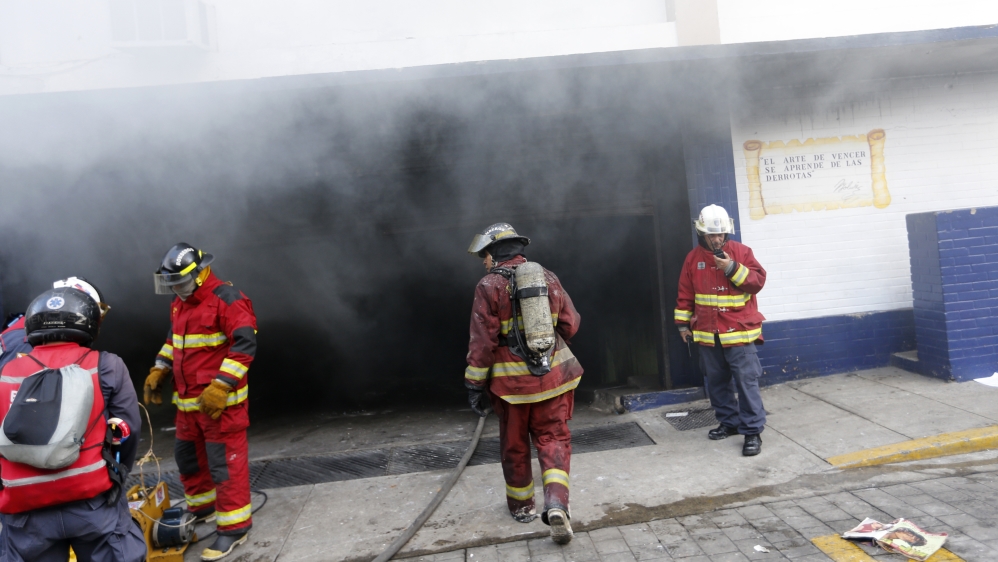 Firefighters extinguish a blaze at a police station in Caracas set on fire by protesters [Andres Martinez Casares/Reuters]